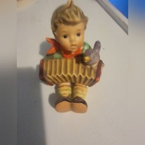 Hummel Goebel boy playing an accordion w a bird chirping along.